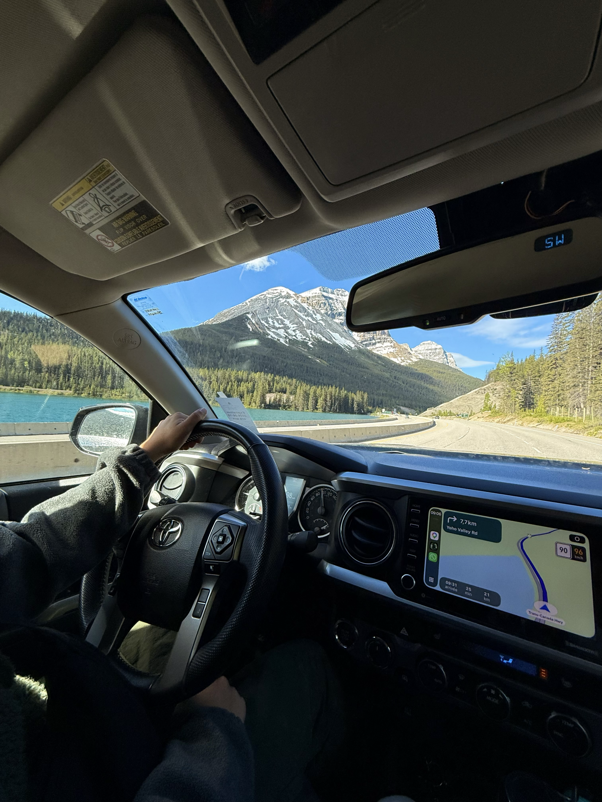 driving through canadian rockies with snow-capped mountains and turquoise lake