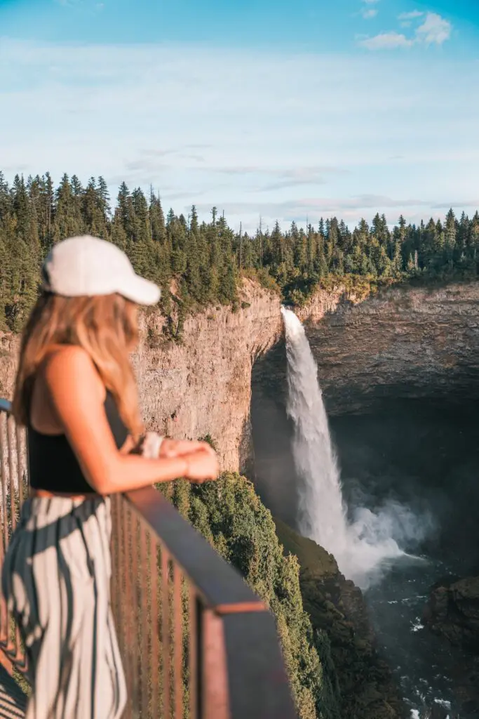 woman in white cap looking at Helmcken Falls in Canada